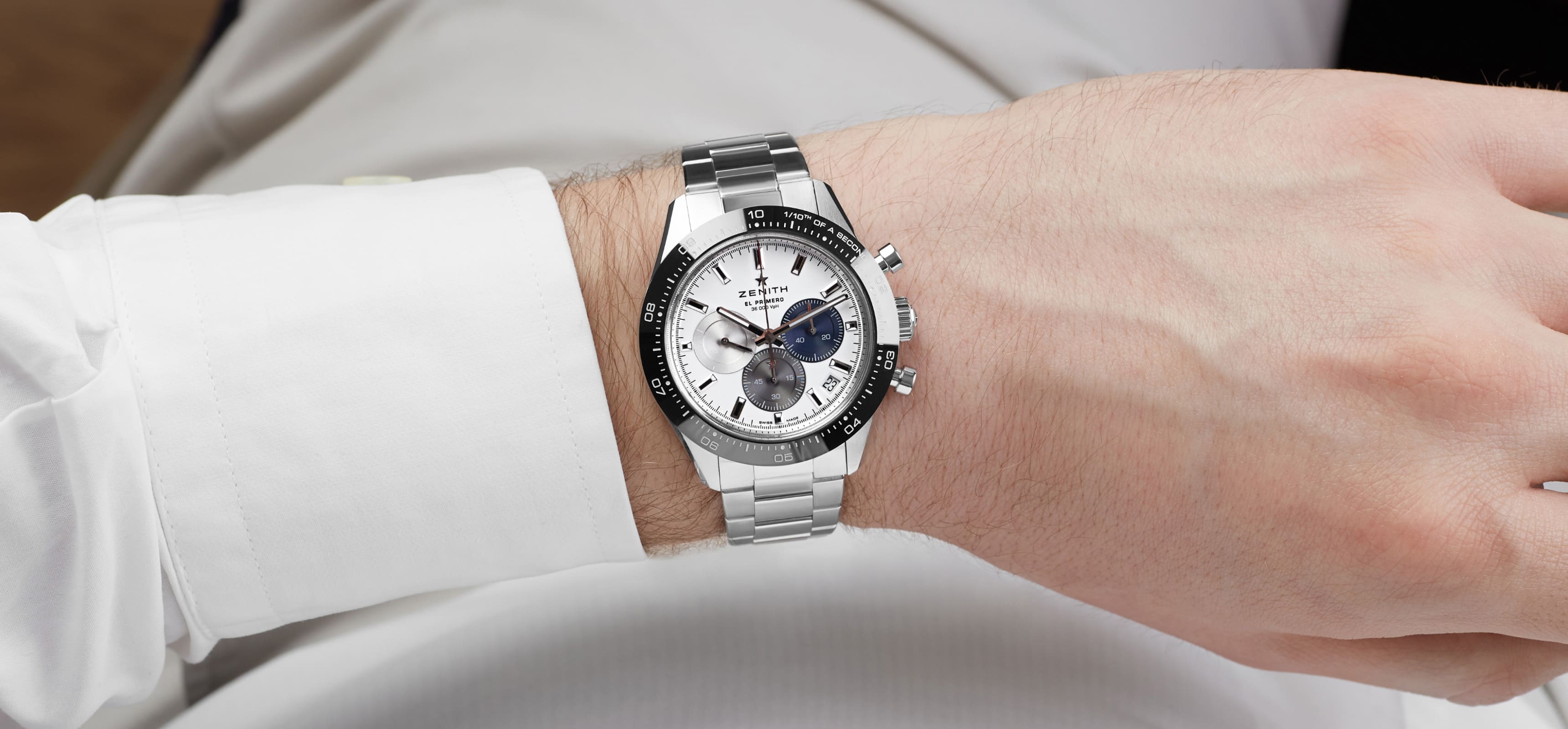 Silver luxury watch on a man's wrist. Rich and shimmering watch approach design.