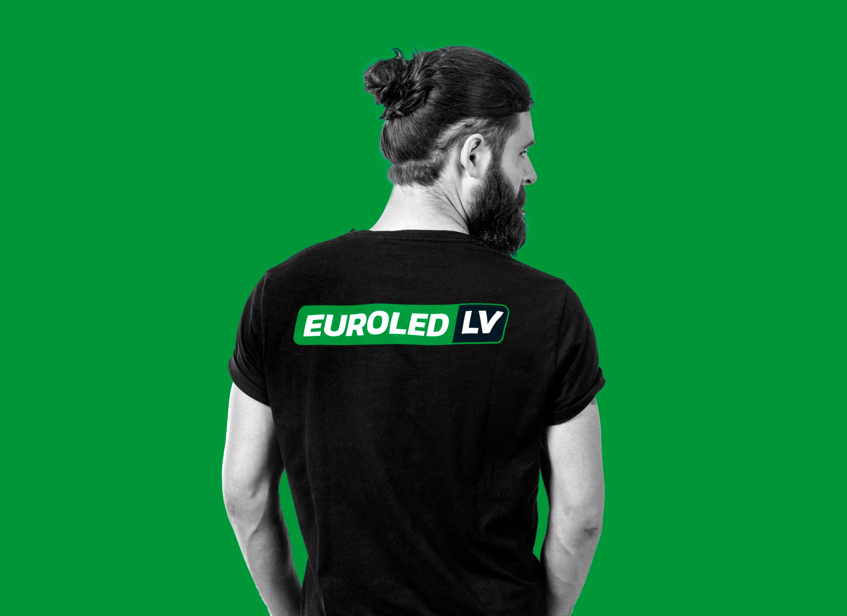Vīrietis uz zaļa fona ģērbies T-kreklā ar uzrakstu EUROLED LV, uzņēmuma EUROLED zīmola vizualizācija